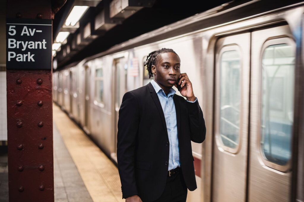 young office worker talking on phone at metro station
