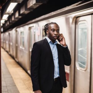 young office worker talking on phone at metro station