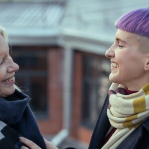 women wearing scarves smiling at each other